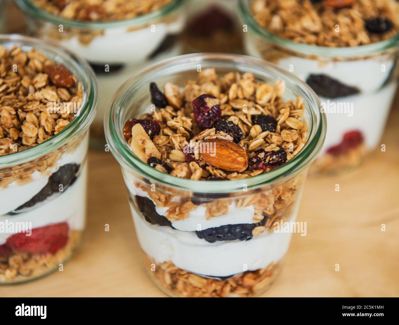 Portionen Joghurt mit Obst und Müsli Stockfoto