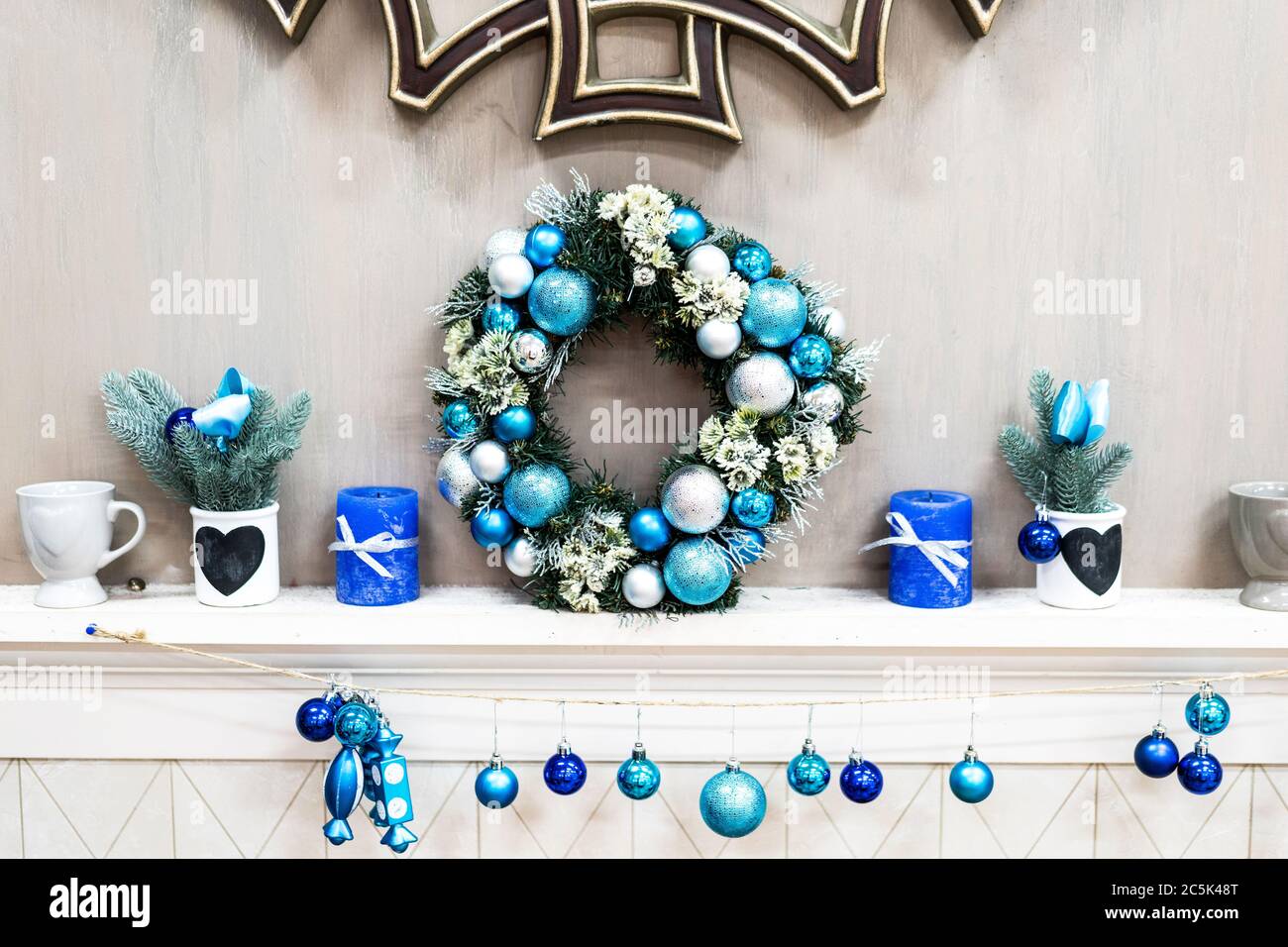 Inspirierende Neujahrsgestaltung Mit Weihnachtskranz Mit Kleinen Farbigen Neujahrsdekorationen Auf Weißem Kommode. Atmosphäre Für Einen Familienurlaub Stockfoto