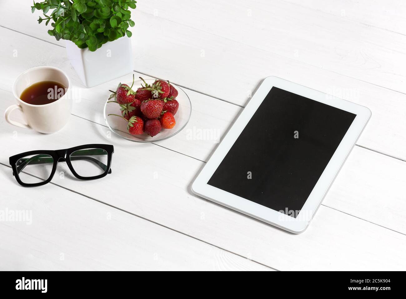 Blumentopf, Brille, Tablet auf weißem Desktop Stockfotografie - Alamy
