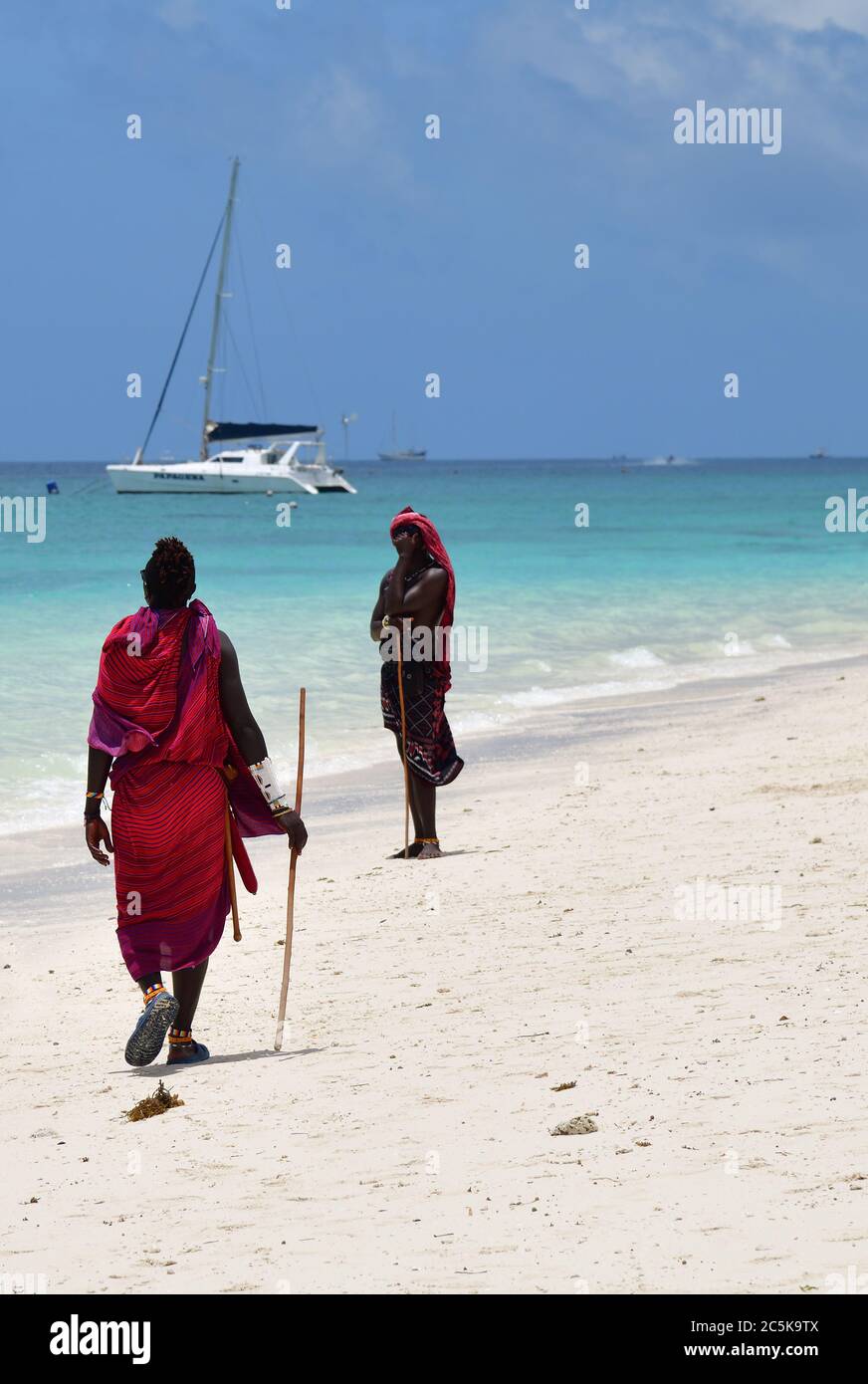 Kendwa, Sansibar - 3. Oktober 2019: Mann aus dem Massai-Stamm in traditionellen Kleidern spaziert am Kendwa-Strand entlang. Tansania, Afrika Stockfoto