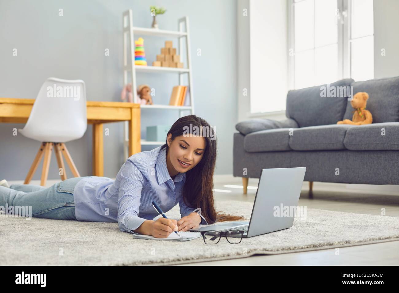 Arbeiten Sie von zu Hause aus. Schöne Frau Notizen während Online-Geschäftskonferenz oder Bildungskurs auf Laptop im Zimmer Stockfoto