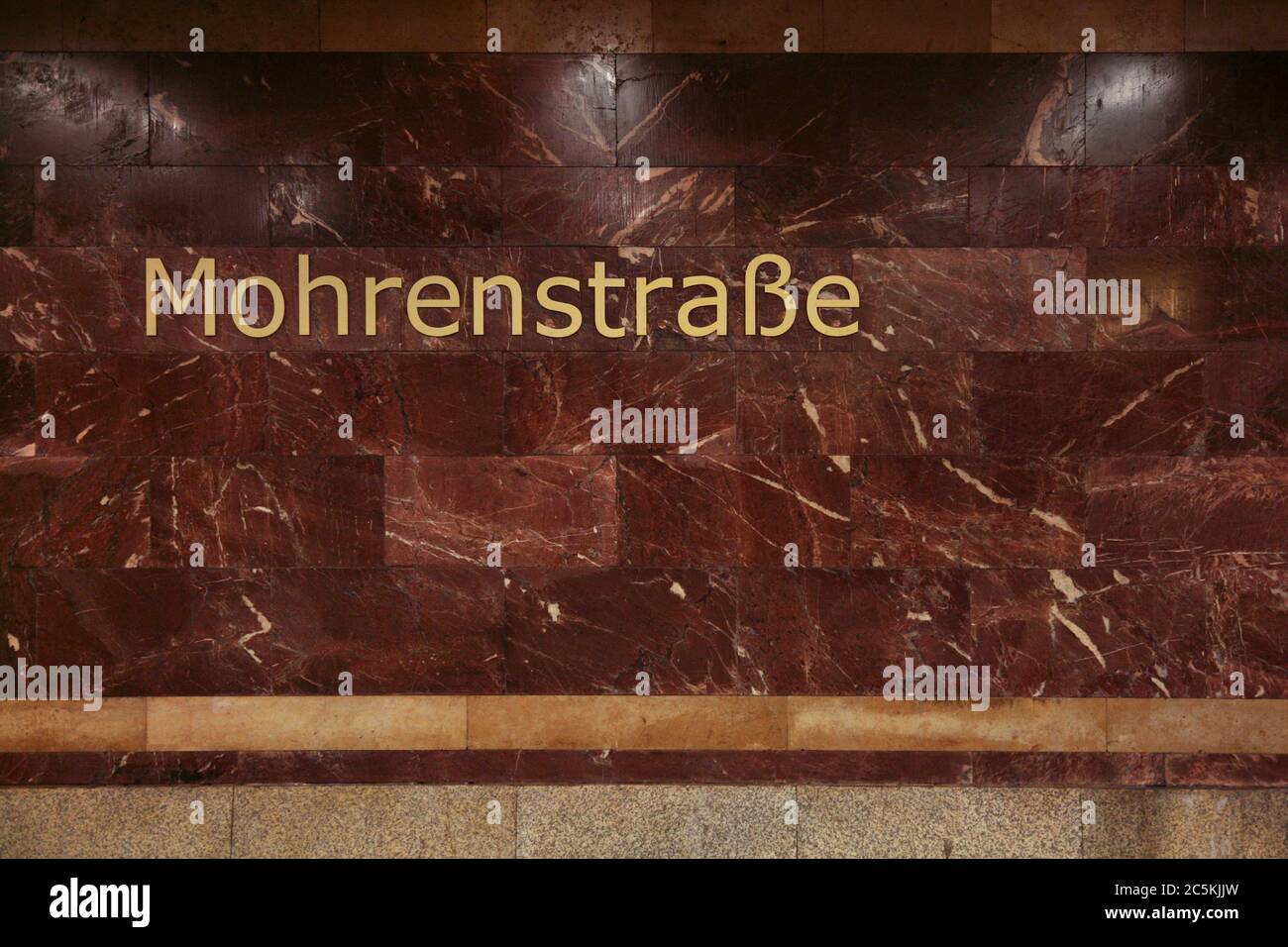 U-Bahn-Station Mohrenstraße in Berlin, Deutschland. Der städtischen Legende nach wurde der rote Stein, der in den 1950er Jahren zur Umgestaltung des Bahnhofs verwendet wurde, aus den Ruinen der Reichskanzlei entnommen, die in der Nähe des Bahnhofs gestanden hatten. Stockfoto
