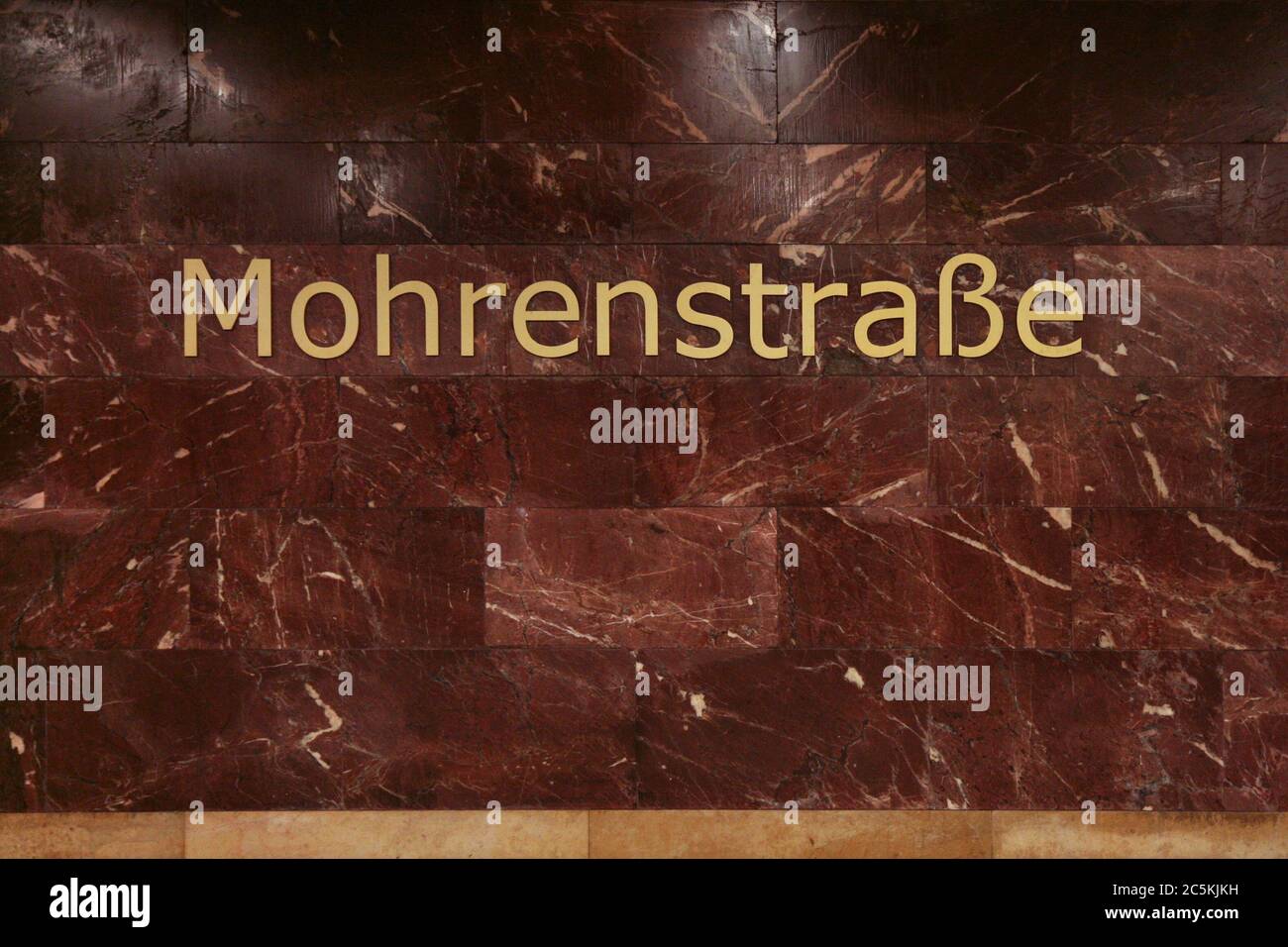 U-Bahn-Station Mohrenstraße in Berlin, Deutschland. Der städtischen Legende nach wurde der rote Stein, der in den 1950er Jahren zur Umgestaltung des Bahnhofs verwendet wurde, aus den Ruinen der Reichskanzlei entnommen, die in der Nähe des Bahnhofs gestanden hatten. Stockfoto