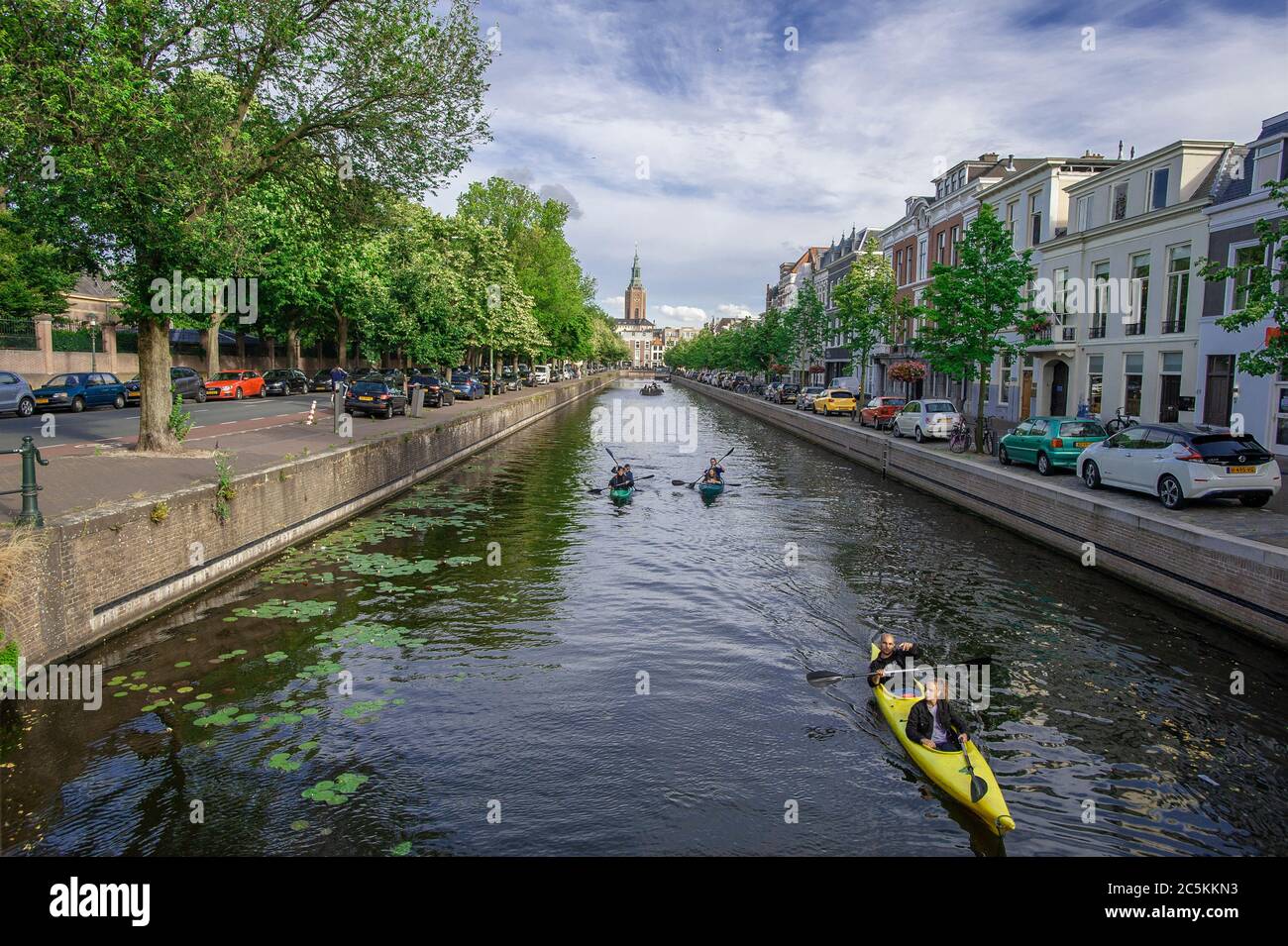 Kanute auf der Toussaintkade Kanel und die 15. Jahrhundert Grote oder St, Jacobskerk im Hintergrund. Freitagabend in Den Haag, da die vielen Wochen der Lockdown gelockert werden und eine Form der Normalität zur sozialen Norm wird. Kredit: Charles M Vella/Alamy Live Nachrichten Stockfoto