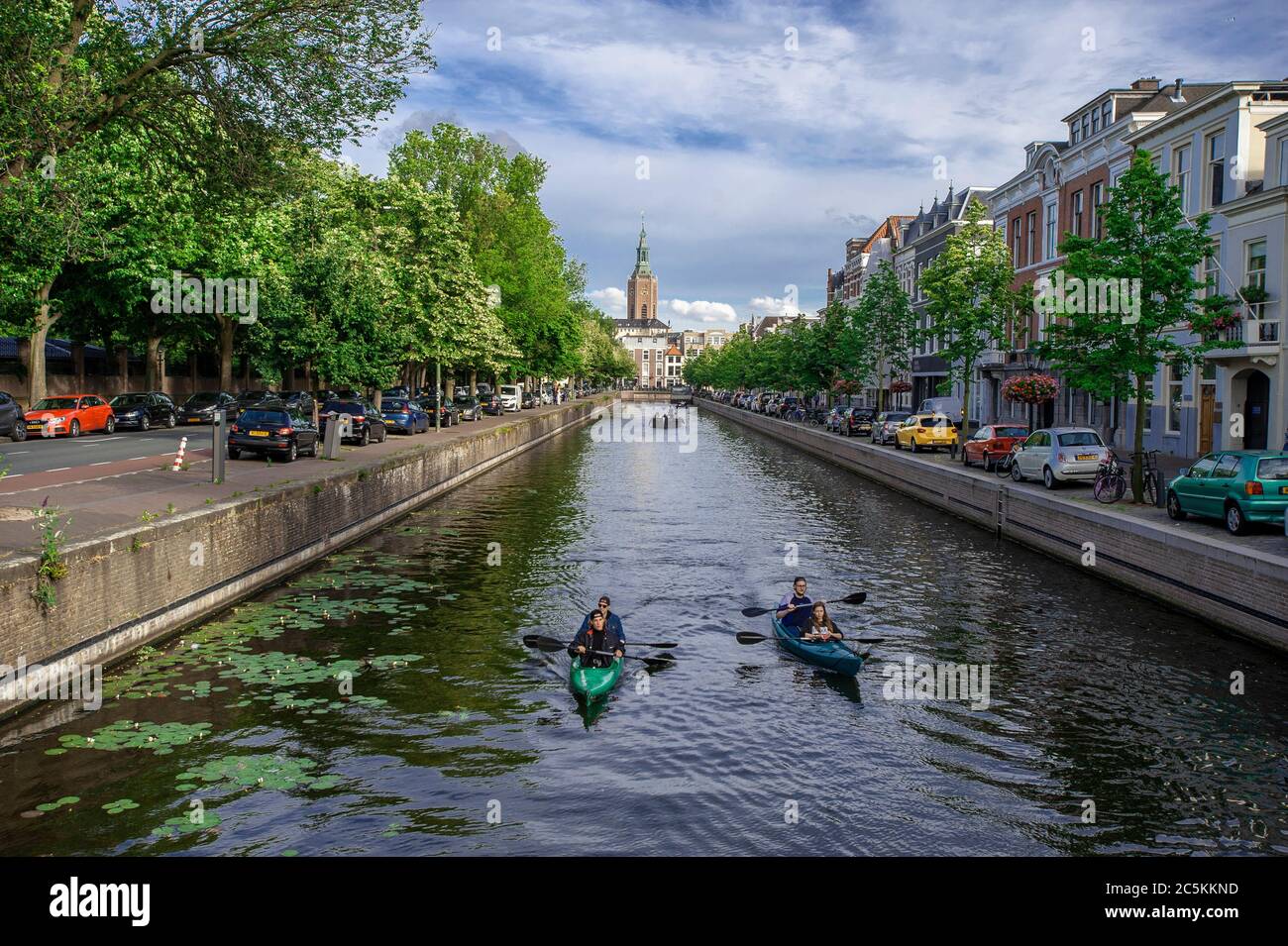 Kanute auf der Toussaintkade Kanel und die 15. Jahrhundert Grote oder St, Jacobskerk im Hintergrund. Freitagabend in Den Haag, da die vielen Wochen der Lockdown gelockert werden und eine Form der Normalität zur sozialen Norm wird. Kredit: Charles M Vella/Alamy Live Nachrichten Stockfoto