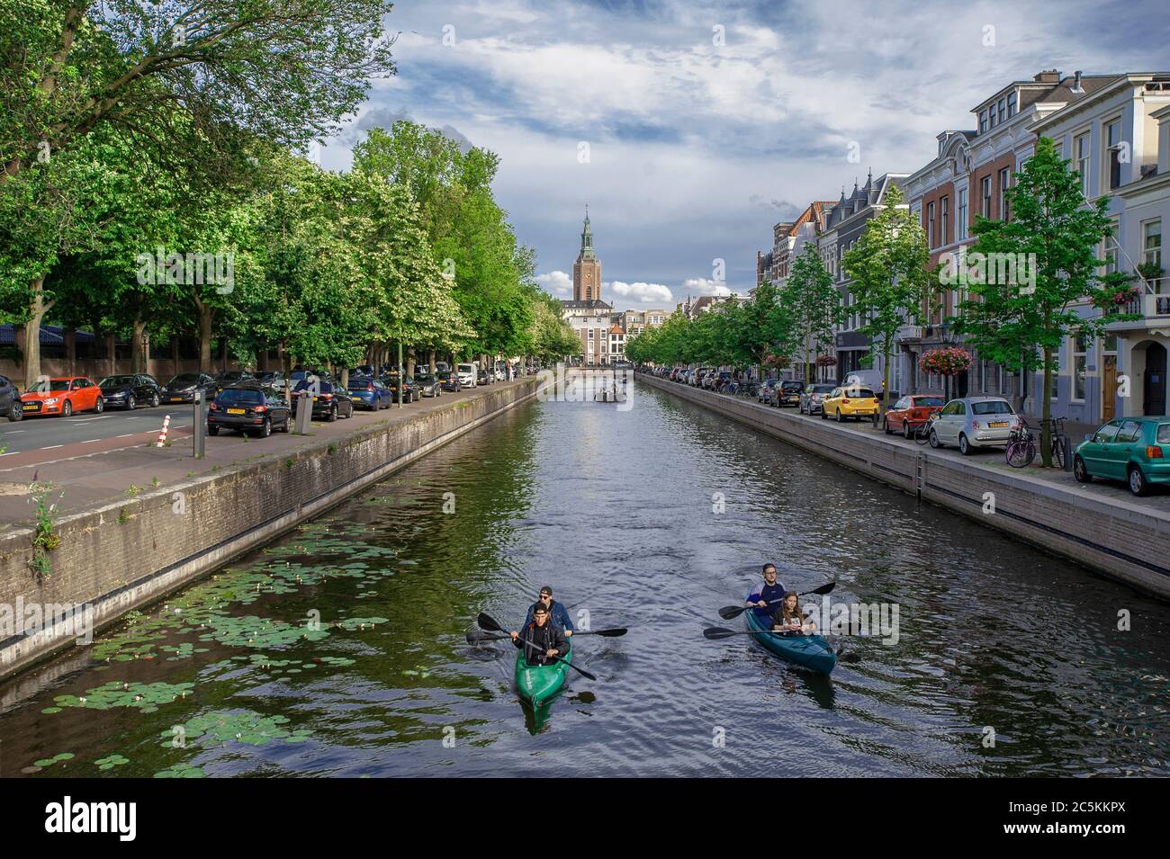 Kanute auf der Toussaintkade Kanel und die 15. Jahrhundert Grote oder St, Jacobskerk im Hintergrund. Freitagabend in Den Haag, da die vielen Wochen der Lockdown gelockert werden und eine Form der Normalität zur sozialen Norm wird. Kredit: Charles M Vella/Alamy Live Nachrichten Stockfoto