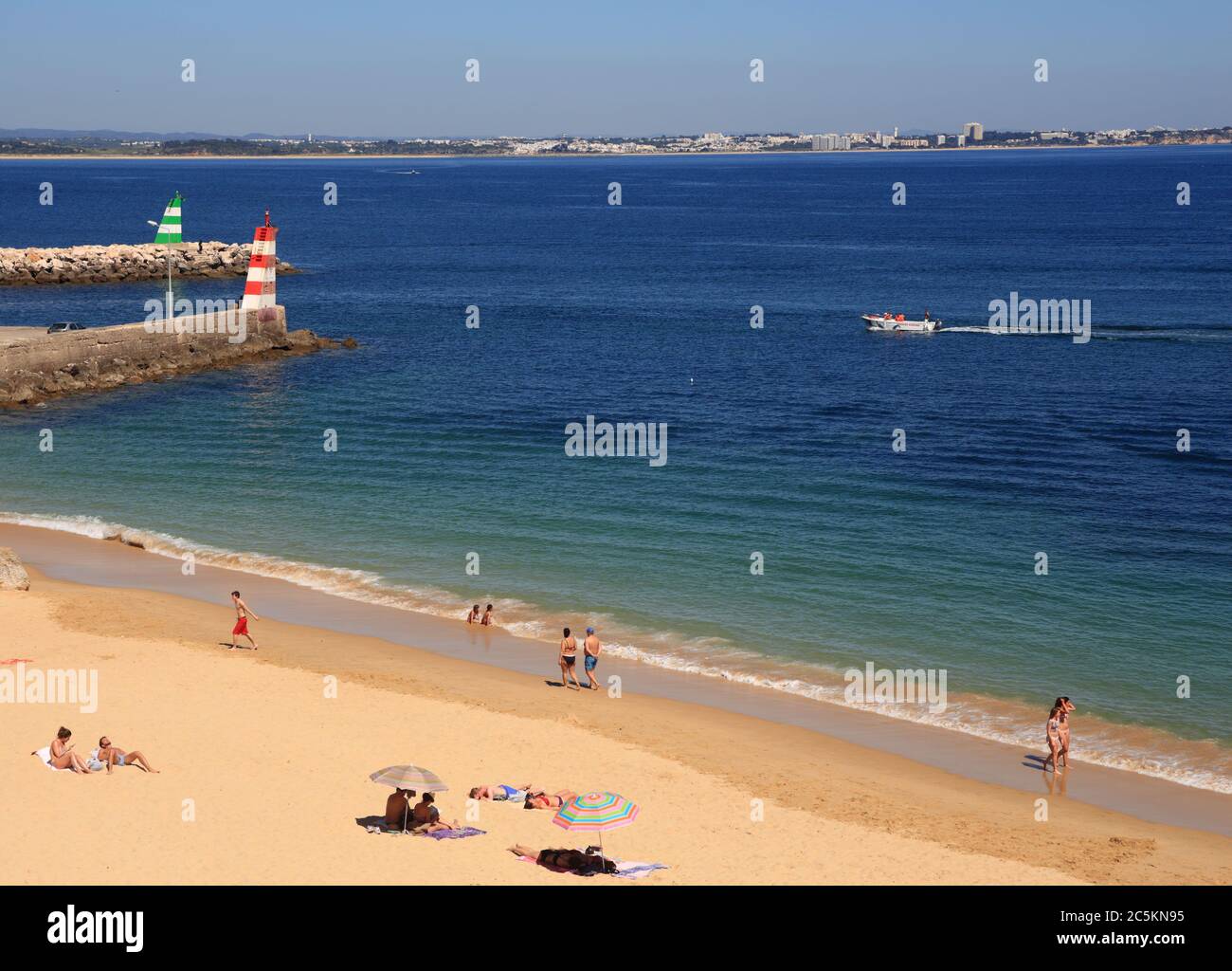 Lagos, Algarve, Portugal. Blick auf die Klippen von Touristen, die sich in der warmen Sonne am Stadtstrand in Lagos, in der westlichen Algarve sonnen. Stockfoto