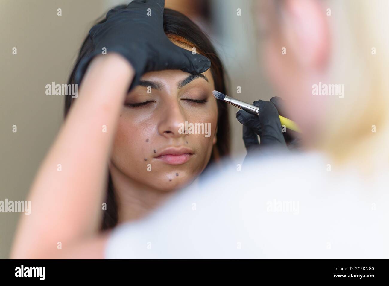 Make-up Frau Künstler bei der Arbeit, professionell in Aktion mit jungen Modell in Schönheitssalon und kreative Klassen Stockfoto