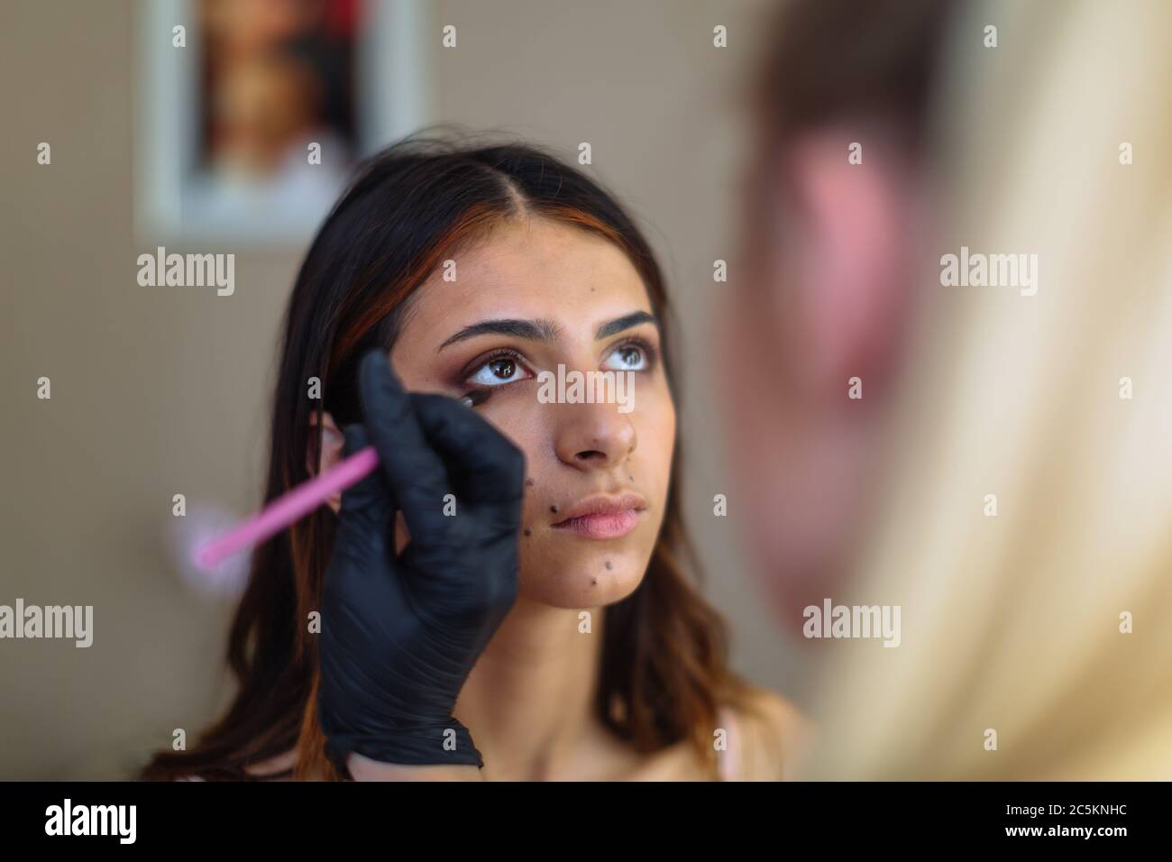 Make-up Frau Künstler bei der Arbeit, professionell in Aktion mit jungen Modell in Schönheitssalon und kreative Klassen Stockfoto