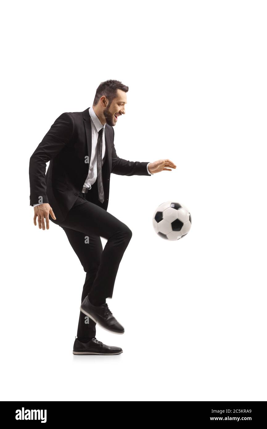 In voller Länge Profilaufnahme eines Mannes in einem Anzug tritt ein Fußball isoliert auf weißem Hintergrund Stockfoto