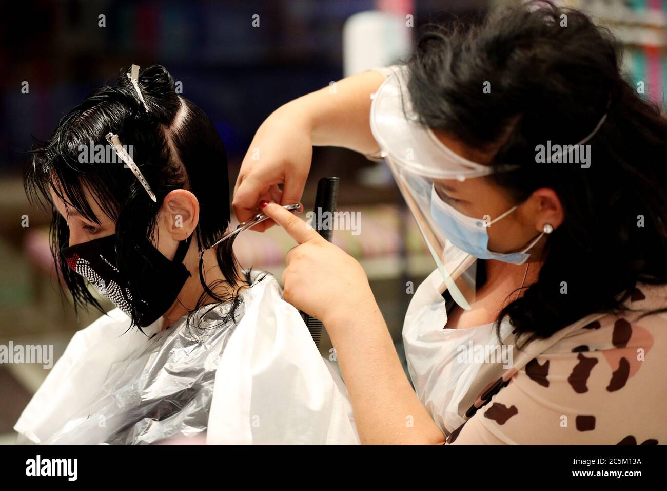 Stylistin Hayley Hehir (rechts) schneidet die Haare der Kundin Francesca Shashkova (links) bei Tusk Hair in Camden, North London, nachdem sie um Mitternacht für den ersten Kunden nach der Sperre geöffnet wurde, da die Beschränkungen in ganz England gelockert werden. Stockfoto