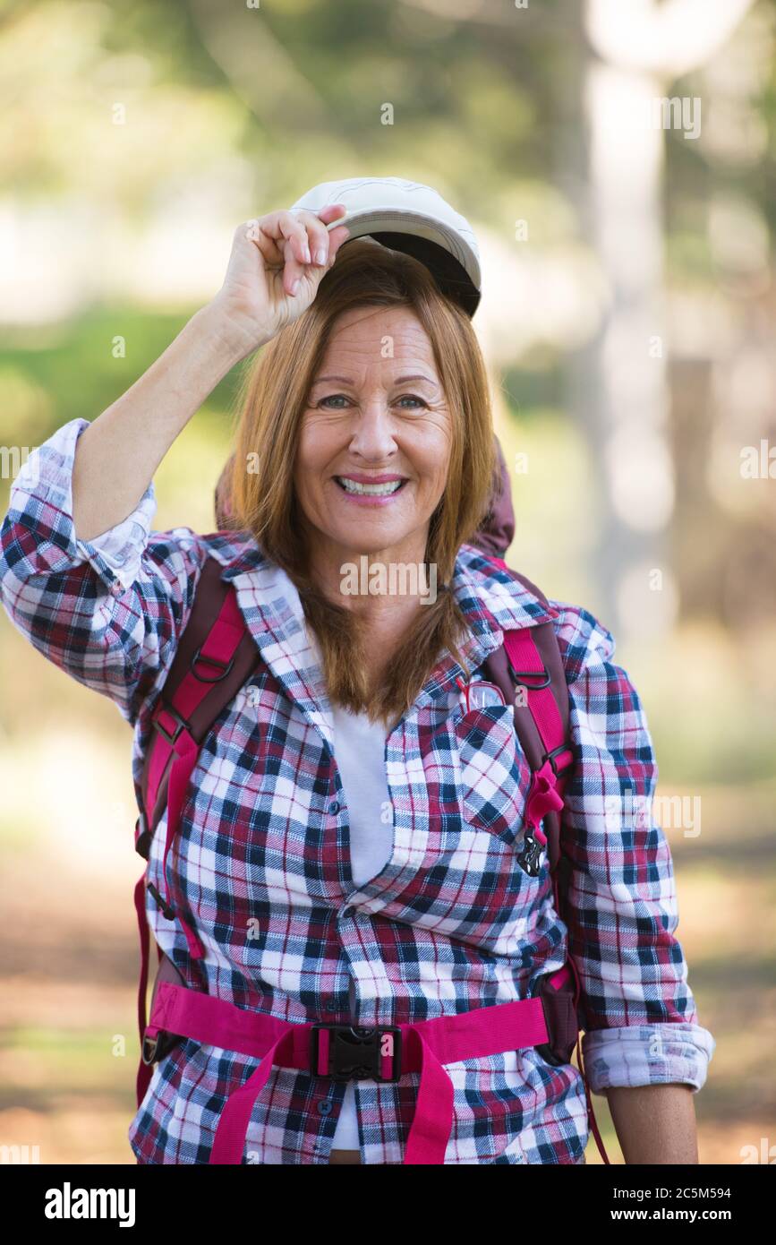 Portrait aktiv Attraktive reife Frau wandern glücklich und entspannt mit Rucksack in den Wäldern, verschwommener Hintergrund. Stockfoto