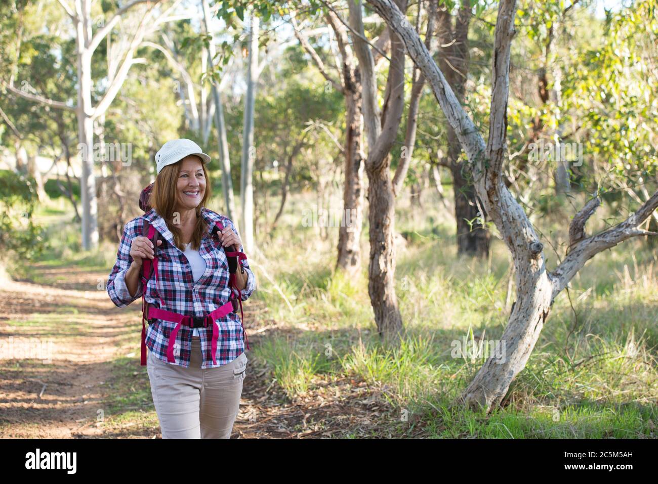 Portrait aktiv Attraktive reife Frau Wandern glücklich und entspannt mit Rucksack in den Wäldern, australische Natur verschwommen Hintergrund. Stockfoto