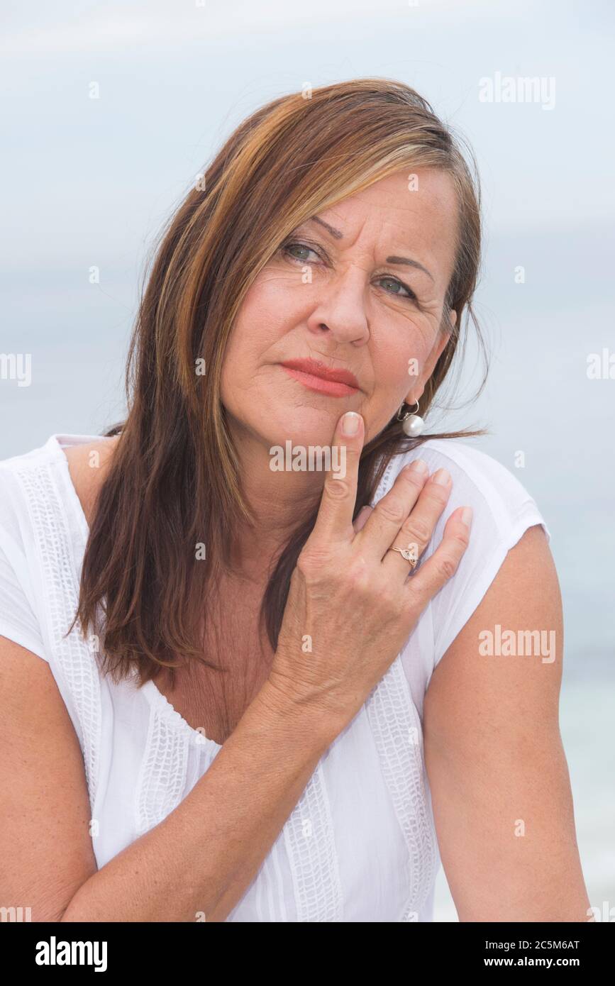 Portrait Attraktive reife Frau, besorgt und besorgt, nachdenklich mit Finger auf Wange. Stockfoto