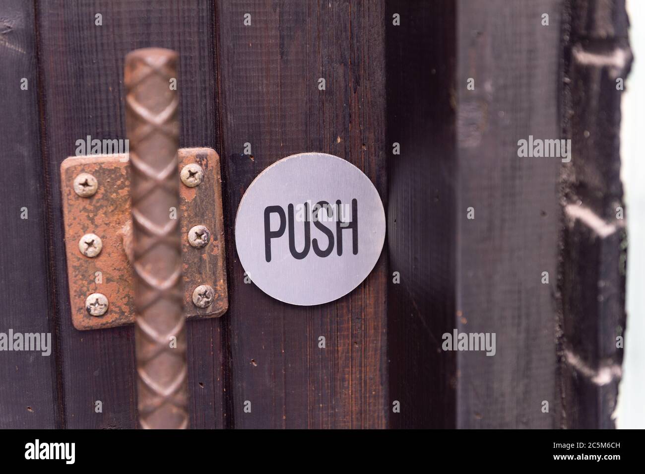Drücken Sie Symbol an der Tür.Ziehen Wort auf Holz Stockfoto