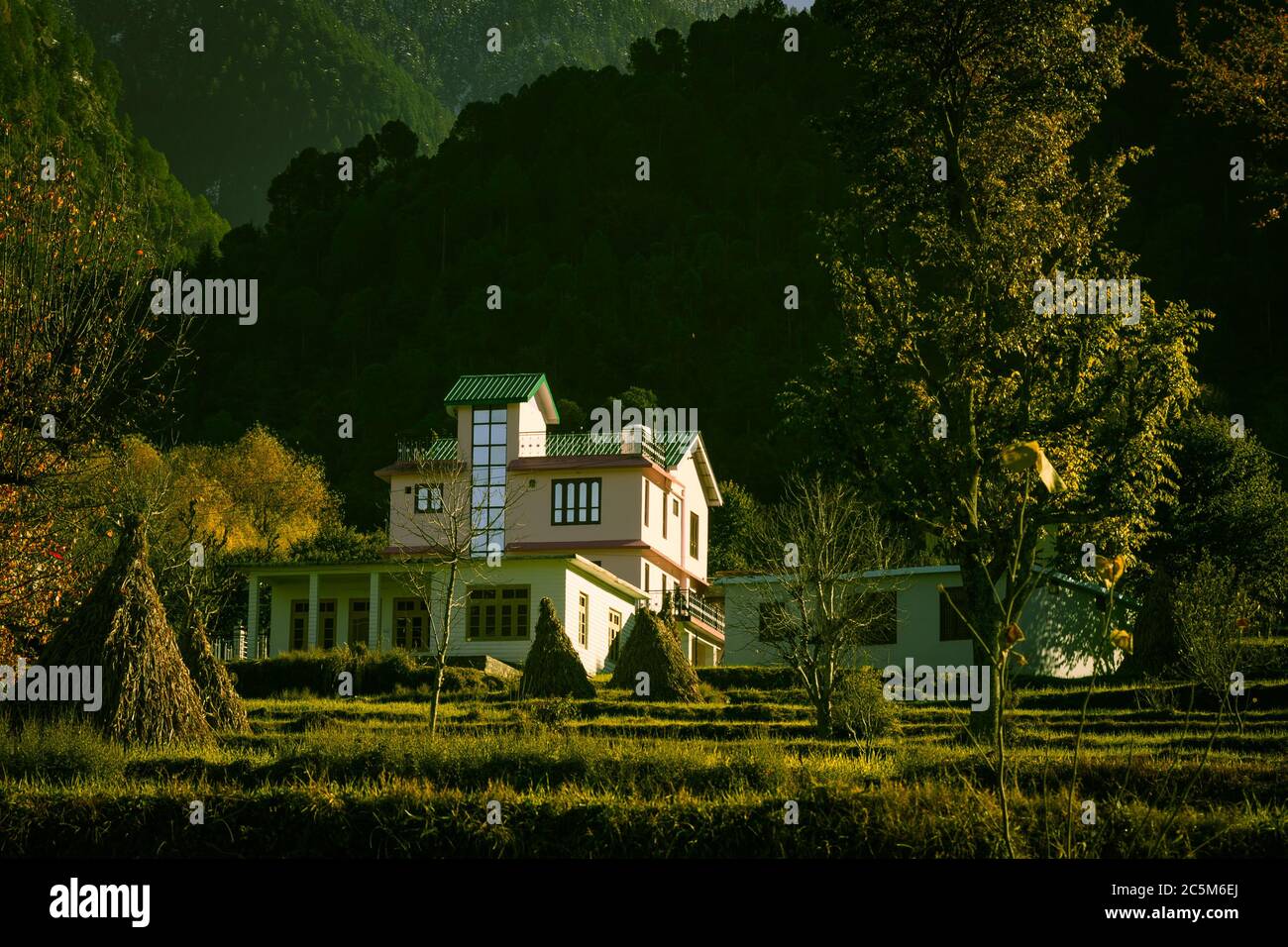 Ein Blick am frühen Morgen auf Häuser in Devi Dehra Dorf im Winter mit riesigen Himalaya-Berge im Hintergrund. Himachal Pradesh, Indien. Stockfoto