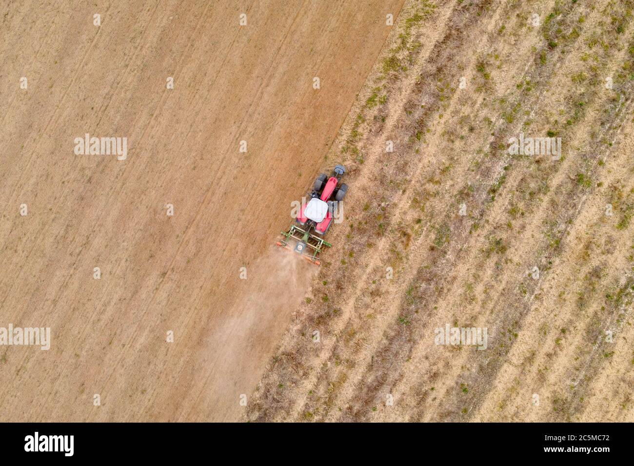 Luftdrohnenansicht eines Traktors, der auf einem Feld pflügt Stockfoto