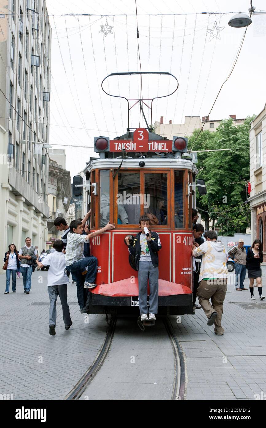 Türkische Jungs fahren mit der Straßenbahn, die entlang Istiklal Caddesi im Stadtteil Beyoglu in Istanbul in der Türkei fährt, kostenlos. Stockfoto