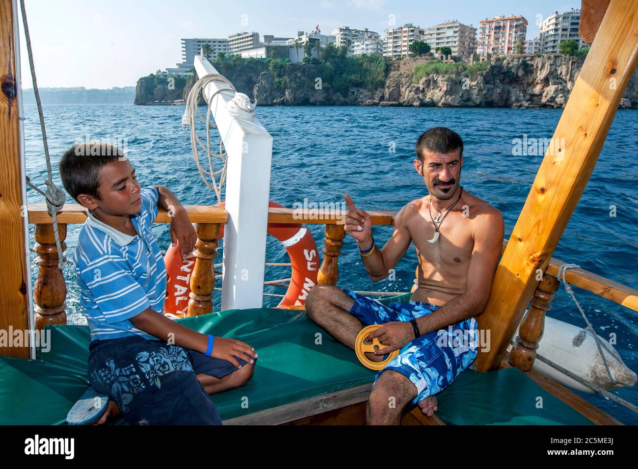 Ein türkischer Mann und Junge fischen von einem Kreuzfahrtschiff mit einer Handschnur in Antalya Bay vor der Küste der Türkei. Stockfoto