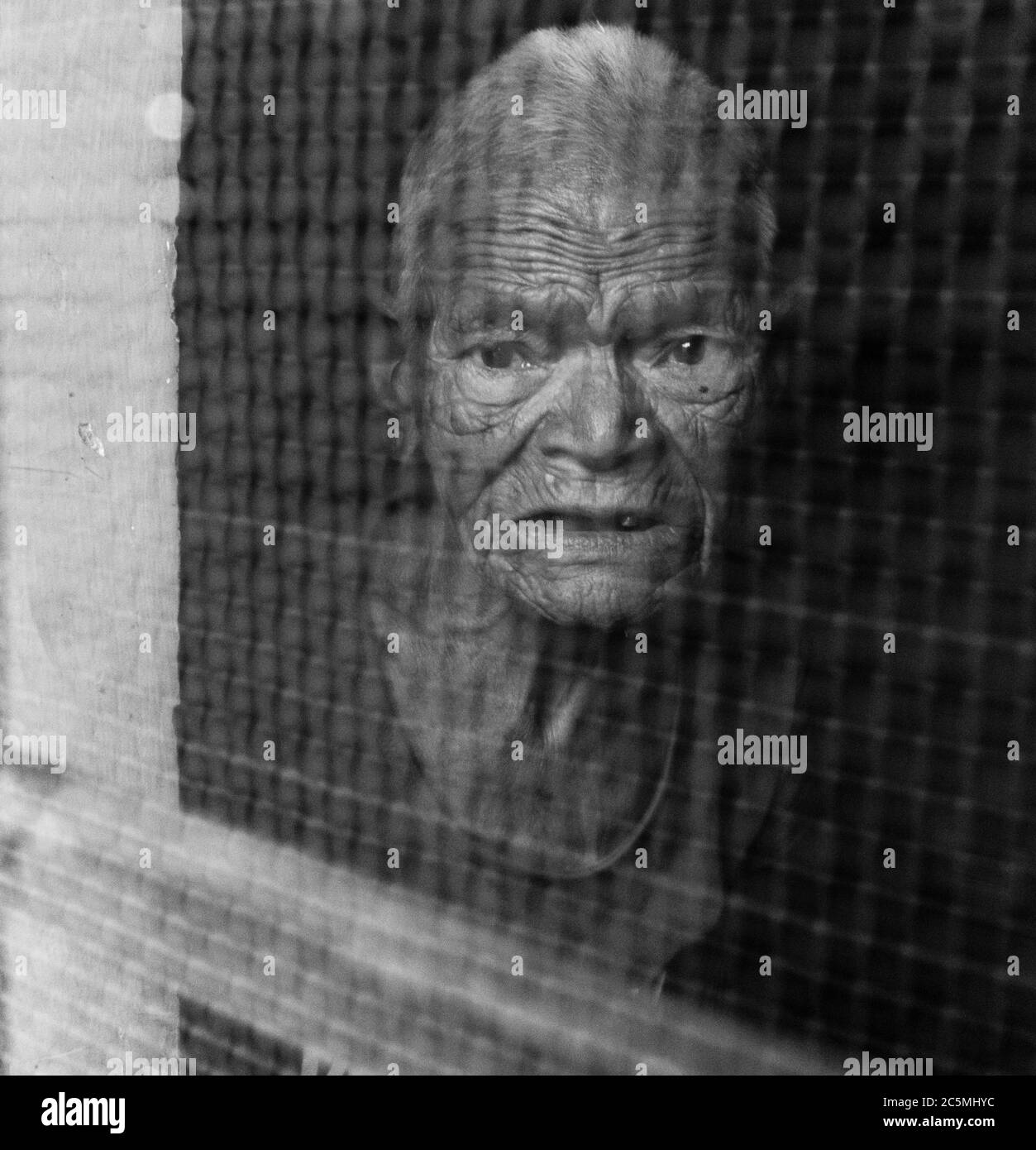 EDITORIAL VOM 29may2020 STANDORT - dehradun Uttarakhand Indien. Eine ältere Frau, die aus dem Fensterzaun schaut. Stockfoto