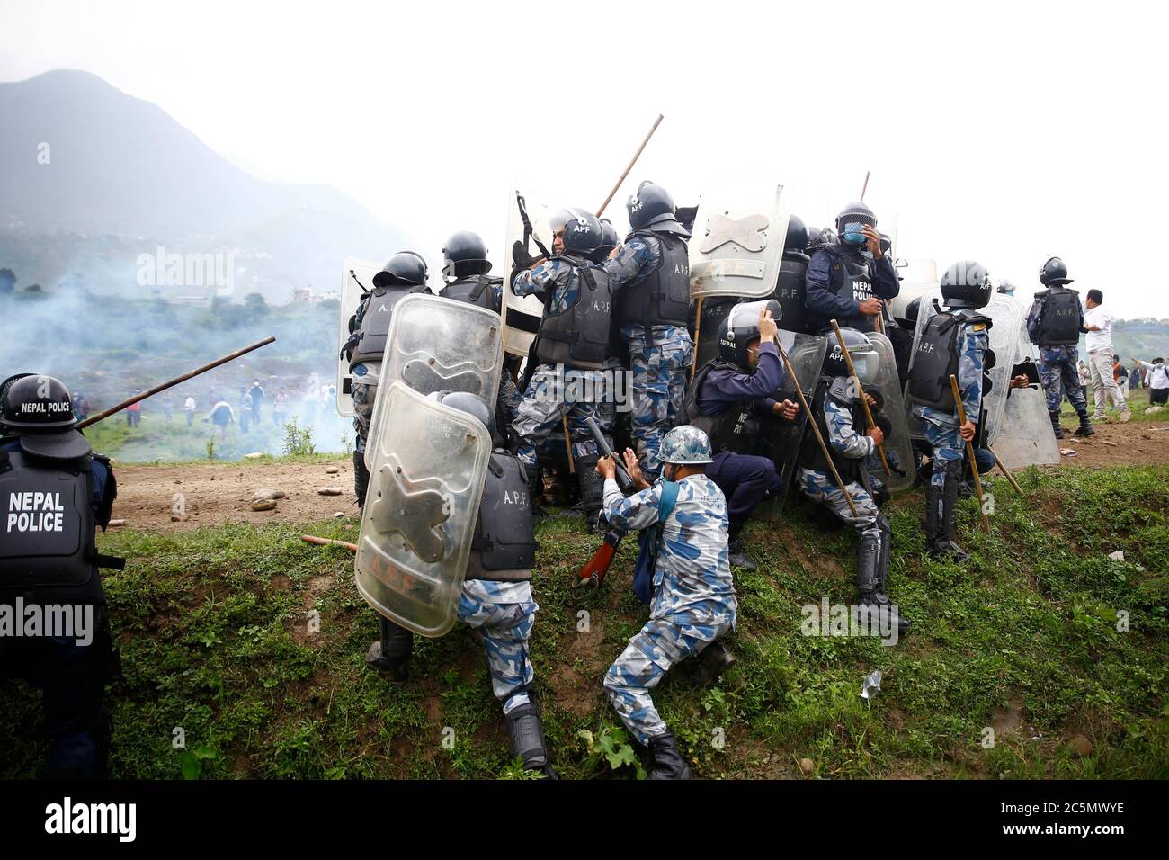 4. Juli 2020, Lalitpur, Nepal: Polizei wacht selbst, als Steine auf sie geworfen wurden, nachdem Einheimische aus Kathmandu, Bhaktapur und Lalitpur stoßen bei einem Protest im Namen des 76.2 Kilometer langen Schnellstraßenprojekts, das am Samstag, 4. Juli 2020, in Khokana in Lalitpur, Nepal, beginnt, auf bewaffnete Polizeikräfte und Mitarbeiter der Riot Police. Die indigenen Newar-Gemeinden Khokana und Bungamati sind besorgt über den Schaden, den die Fast Track-Konstruktion ihrem Eigentum, Land und kulturellen Rechten zufügen könnte. (Bild: © Skanda Gautam/ZUMA Wire) Stockfoto