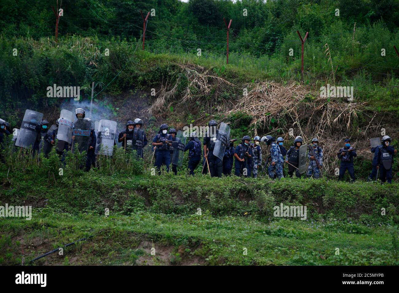 Lalitpur, Nepal. Juli 2020. Die Polizei feuerte Tränengasgranaten, nachdem Einheimische aus Kathmandu, Bhaktapur und Lalitpur am Samstag, den 4. Juli 2020, bei einem Protest im Namen des 76.2 Kilometer langen Schnellstraßenprojekts in Khokana in Lalitpur, Nepal, mit bewaffneten Polizeikräften und Riot-Polizeikräften zusammenprallen. Die indigenen Newar-Gemeinden Khokana und Bungamati sind besorgt über den Schaden, den die Fast Track-Konstruktion ihrem Eigentum, Land und kulturellen Rechten zufügen könnte. Kredit: Skanda Gautam/ZUMA Wire/Alamy Live Nachrichten Stockfoto