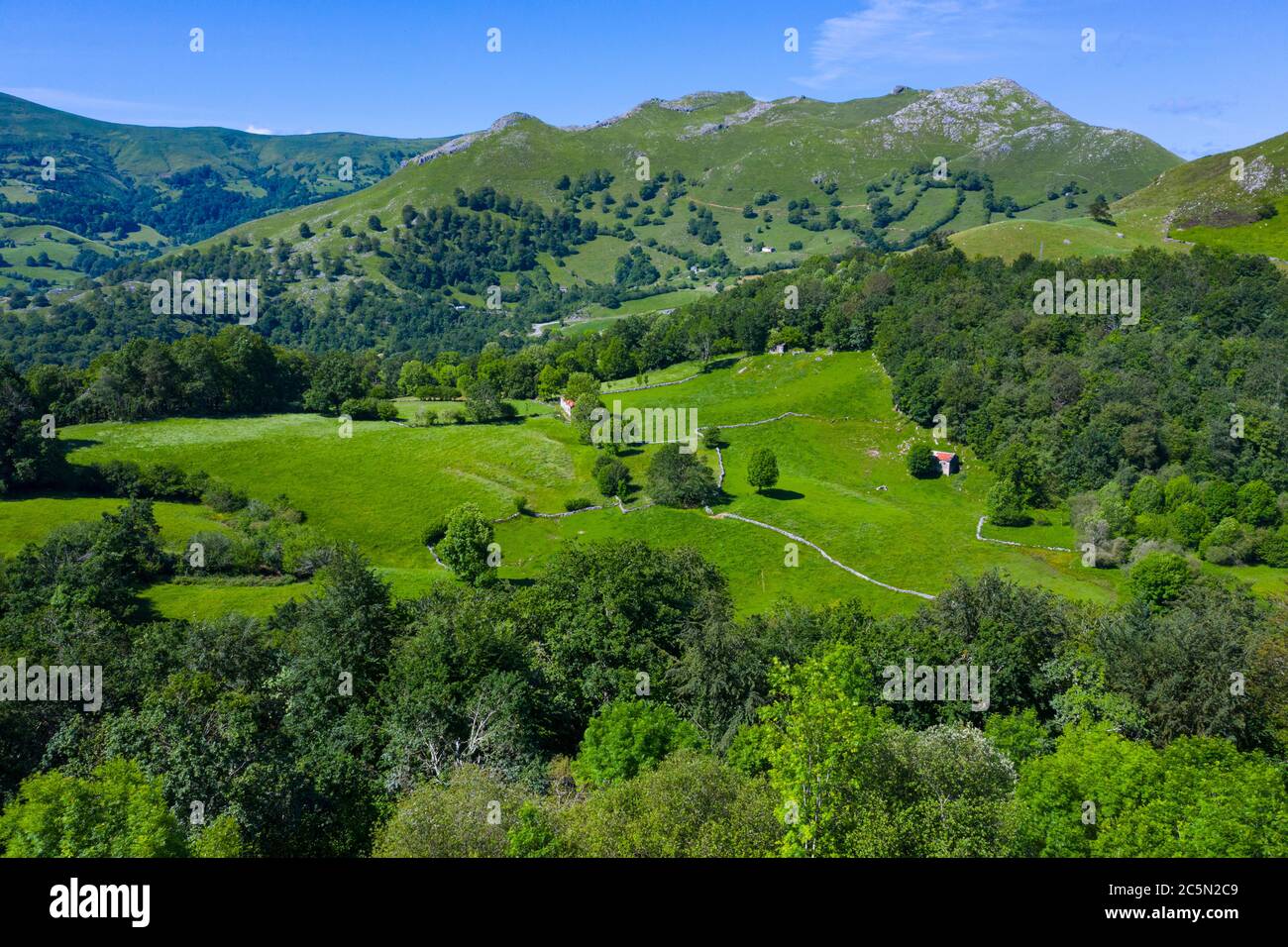 Frühlingslandschaft von Bergen, Wiesen von Mähen und Hütten pasiegas im Miera Tal, Kantabrien, Spanien, Europa Stockfoto