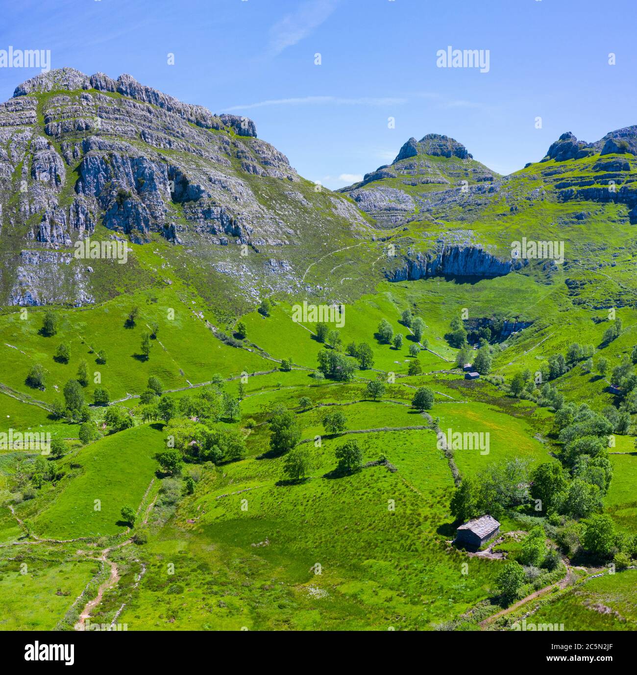 Frühlingslandschaft von Bergen, Wiesen von Mähen und Hütten pasiegas im Miera Tal, Kantabrien, Spanien, Europa Stockfoto