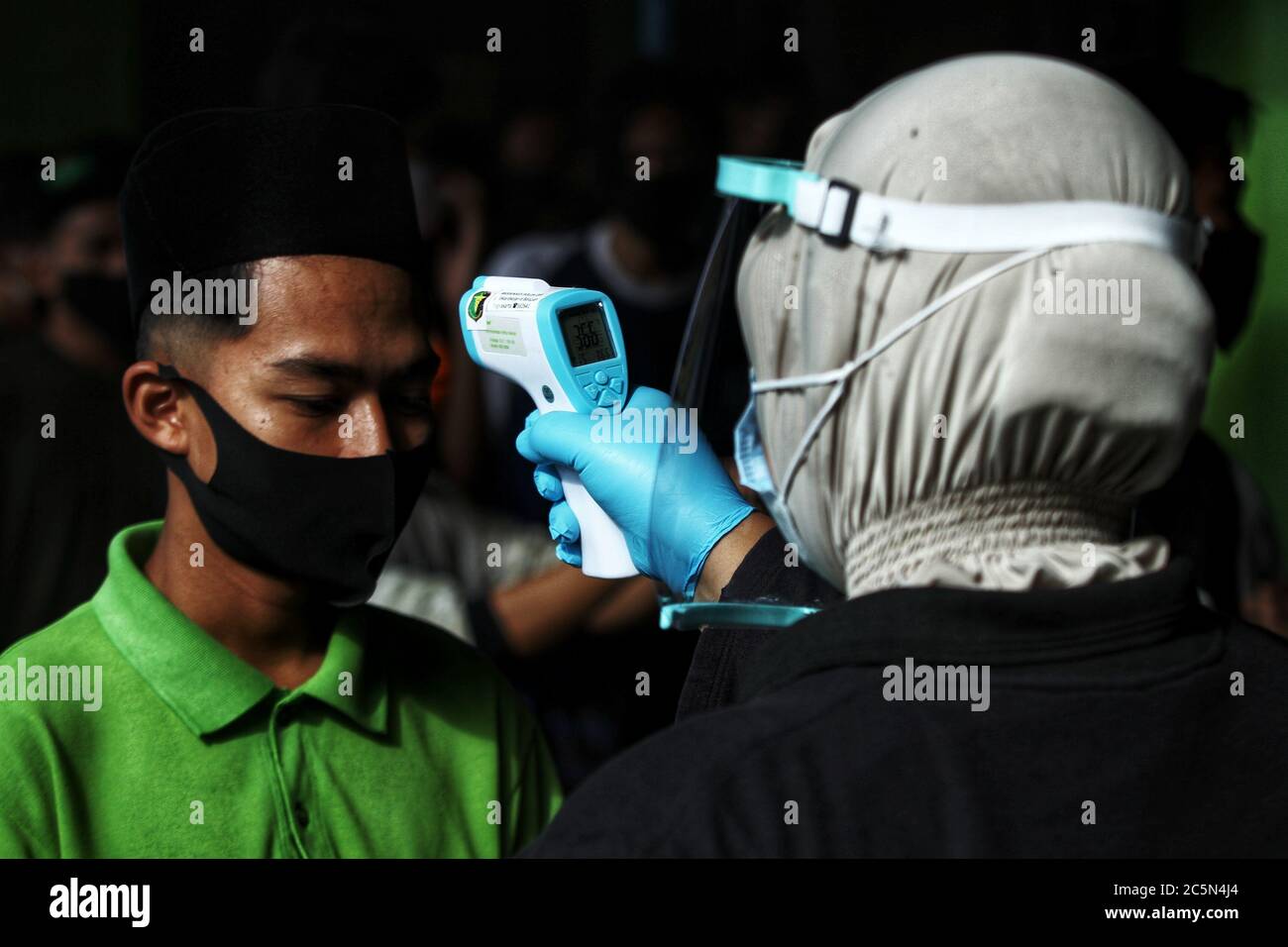 Sleman, Indonesien. Juli 2020. Ein Schüler bekommt Kontrolle Temperatur ein Körper, während Coronavirus-Test an ORA AJI Islamic Boarding School in Sleman, Yogyakarta, Indonesien, am 4. Juli 2020. Hunderte von Studenten nahmen an einem Schnelltest als Vorsichtsmaßnahme für Covid-19 Teil. Lehre und Lernen werden mit der Umsetzung strenger Gesundheitsprotokolle wieder eröffnet. (Foto von Devi Rahman/INA Photo Agency/Sipa USA) Quelle: SIPA USA/Alamy Live News Stockfoto