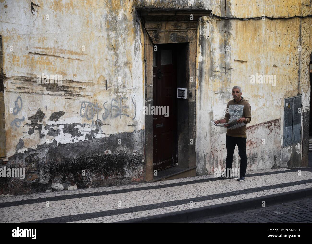 Mann mit offener Zeitung auf einer Straße von madeira portugal Stockfoto
