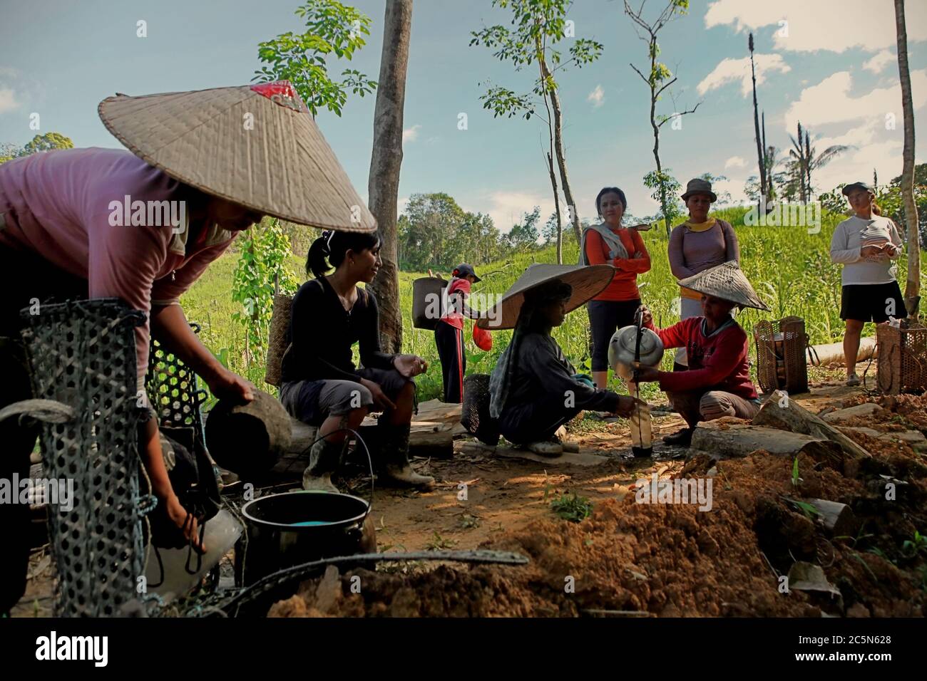 Eine Gruppe von Frauen aus der traditionellen Dayak IBAN-Gemeinde wird fotografiert, während sie sich von einer kommunalen Pflicht zur Sammlung von Nahrungsmitteln aus landwirtschaftlichen Feldern in Sungai Utik, Kapuas Hulu, West Kalimantan, Indonesien, ausruhen. Stockfoto