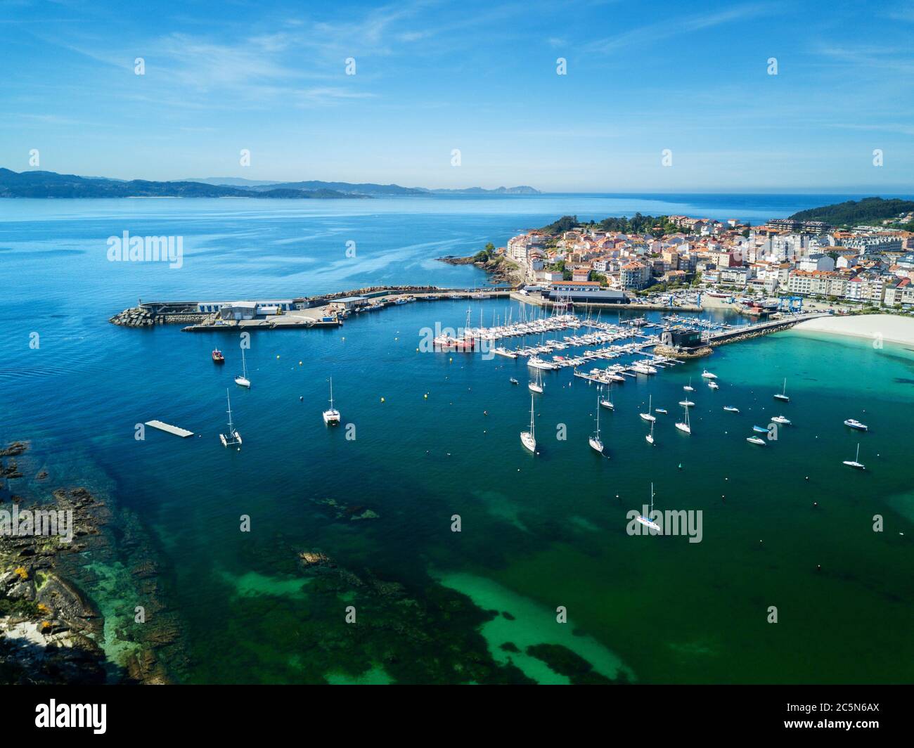 Felsen, Boote und kleiner Leuchtturm im Hafen von Portnovo, Galicien, Spanien. Stockfoto Felsen, Boote und kleiner Leuchtturm im Hafen von Portnovo, Galicien, Spanien. Stockfoto