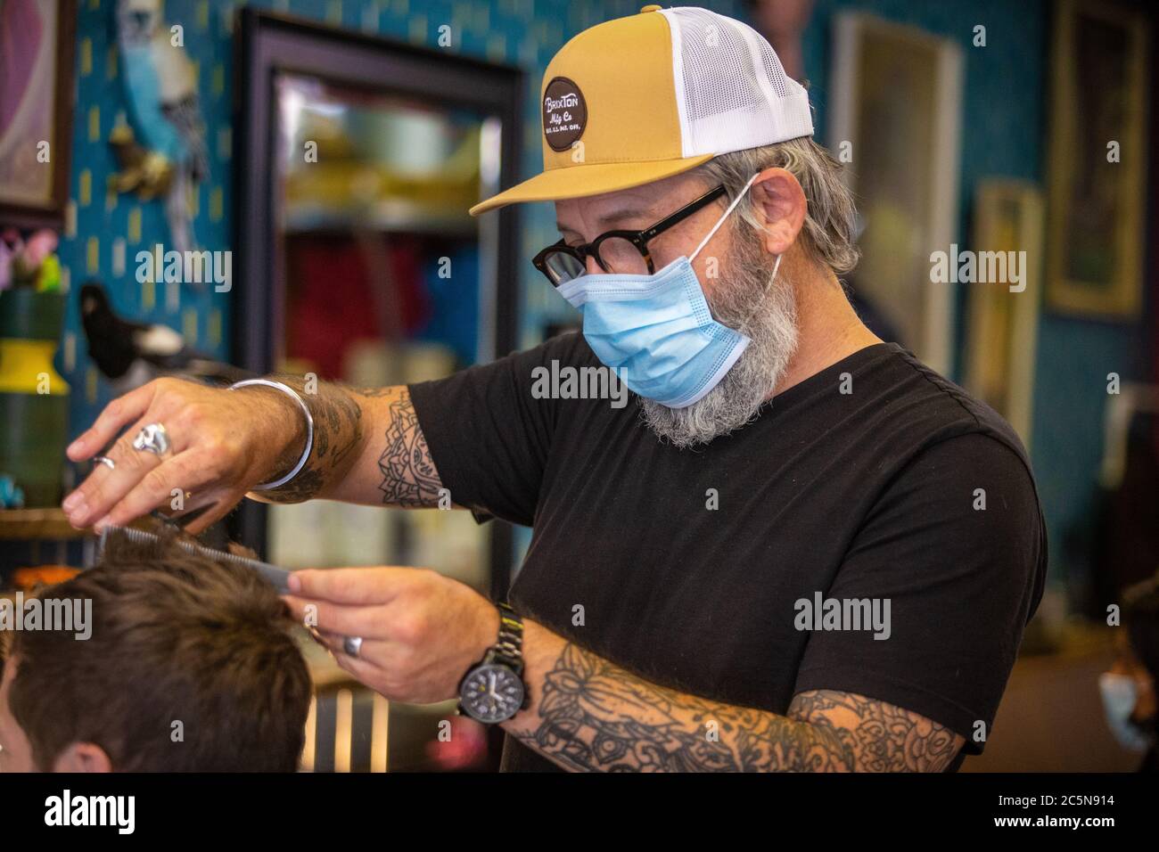 Friseur schneidet Haare tragen PPE Gesichtsmaske im Friseursalon in den ersten Tagen der Lockdown während Coronavirus Pandemie. England Juli 2020 Stockfoto