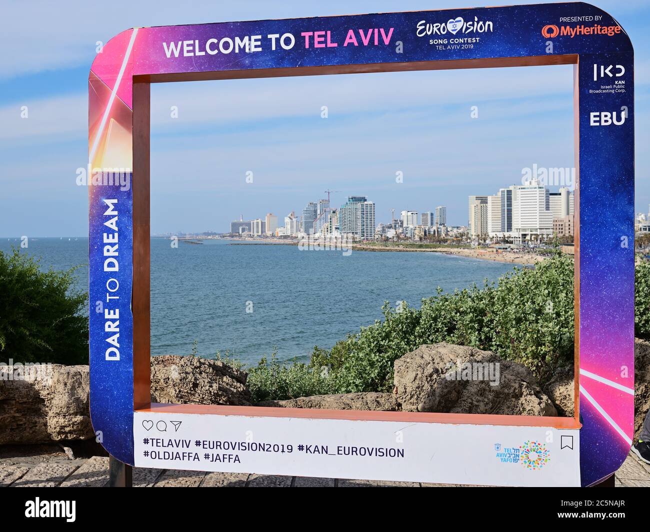 Tel Aviv, Israel - 5. März 2019: Plakat auf der Jaffa Promenade mit offiziellen Eurovision Symbolen Eurovision Song Contest 2019. Skyline von Tel Aviv und ich Stockfoto