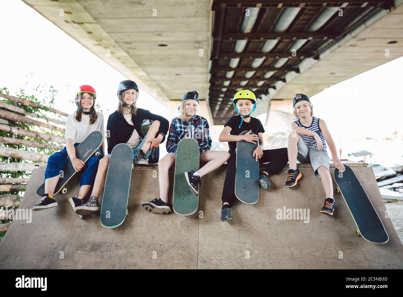 Extremsport in der Stadt. Skateboarding Club für Kinder. Gruppenfreunde posieren auf Rampe im Skatepark. Frühe Jugend im Skate-Training. Freunde Stockfoto