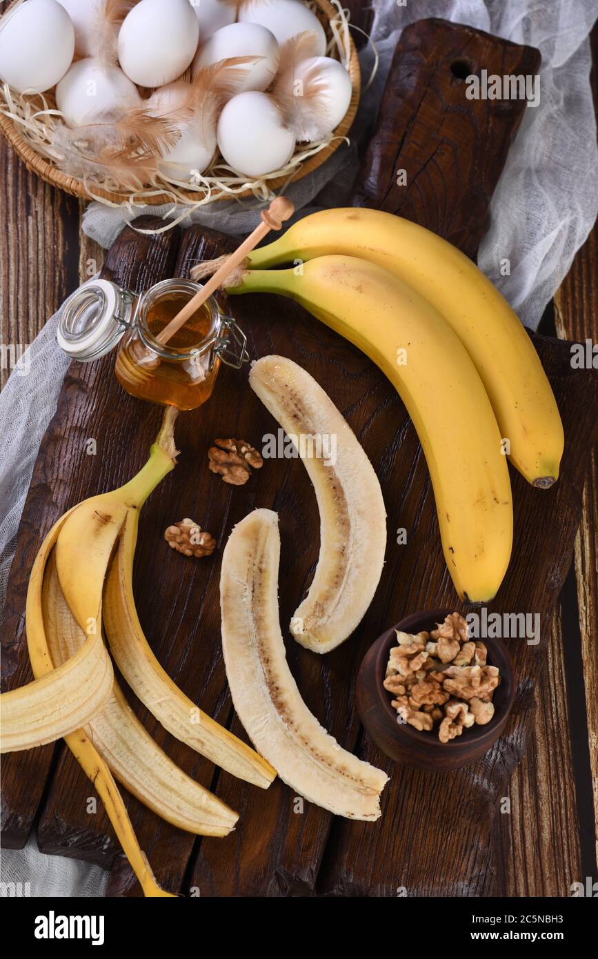 Bananen, Nüsse, Eier, Honig - Zutaten zum Backen hausgemachtes Bananenbrot Stockfoto