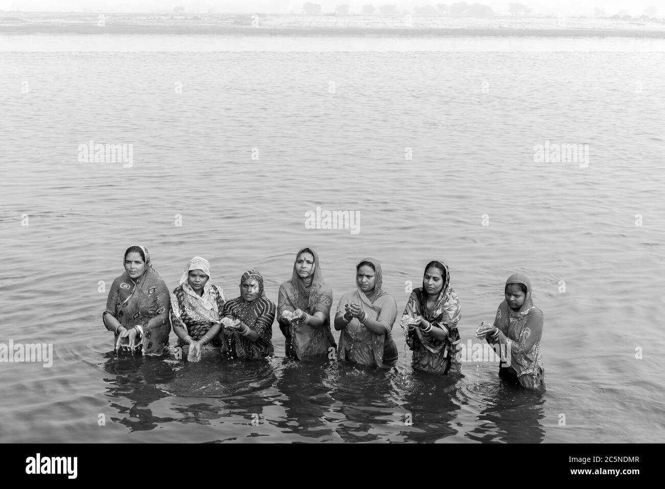Hinduistische Frauen bieten nach einem rituellen Bad im heiligen Yamuna-Fluss in Vrindavan, Uttar Pradesh, Indien, Gebete an. Stockfoto Hinduistische Frauen bieten nach einem rituellen Bad im heiligen Yamuna-Fluss in Vrindavan, Uttar Pradesh, Indien, Gebete an. Stockfoto