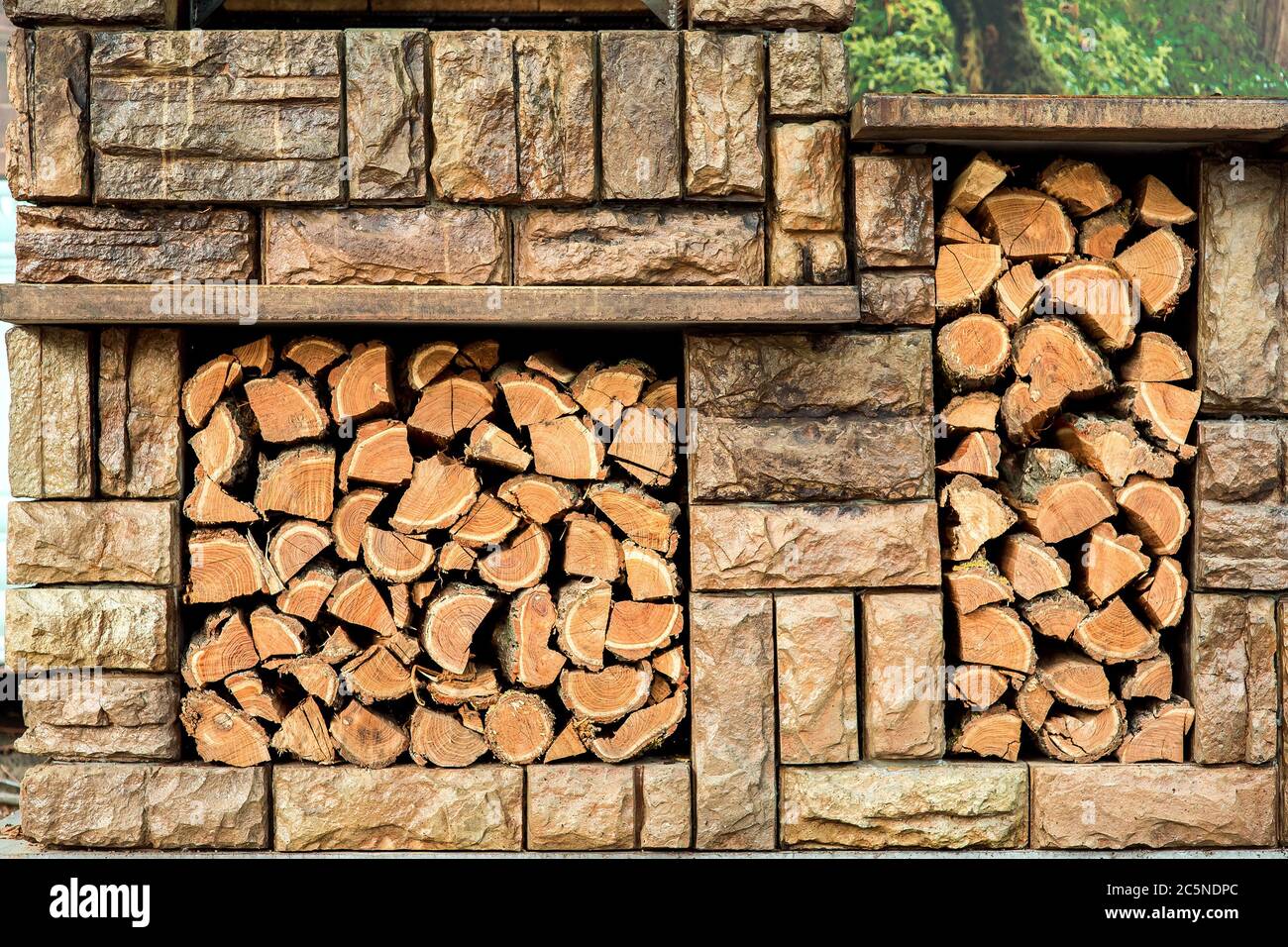 Braune Steingrill mit Stauraum für Ersatz-Brennholz. Stockfoto