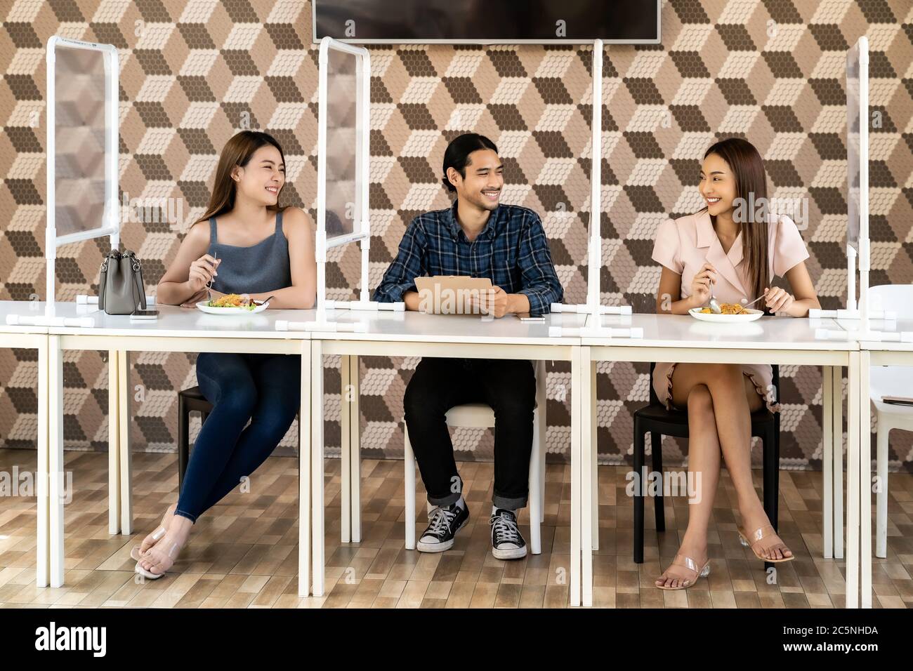 Asiatische Gruppe von Freunden essen zusammen in neuen normalen sozialen Abstand Restaurant mit Tisch gespalten Partition reduzieren Infektion von Coronavirus covid-1 Stockfoto