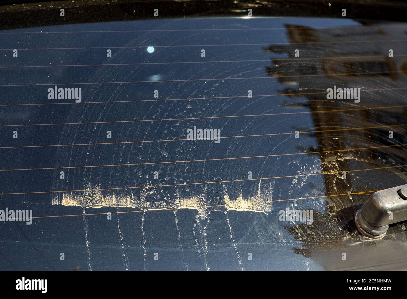 Glas eines schmutzigen Autos in Flecken von Schmutz und Staub nach der Reinigung mit einem Auto Wischer Nahaufnahme der Heckscheibe. Stockfoto