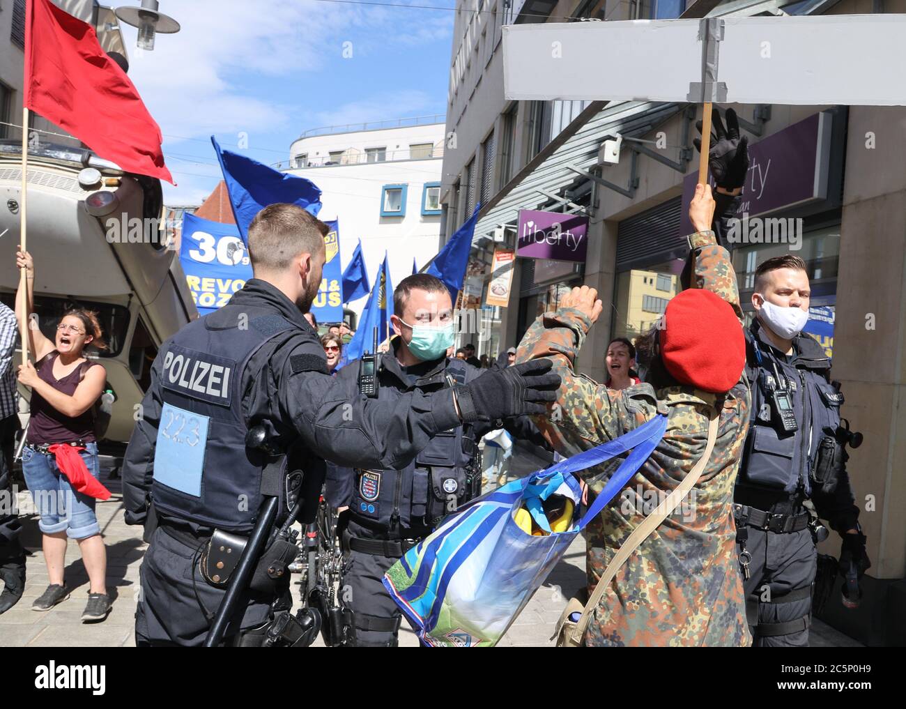 Jena, Deutschland. Juli 2020. Ein Gegendemonstrator wird von der Polizei am Rande einer Demonstration der Freien Deutschen Jugend (FDJ) weggeschoben. Das Motto der Organisation lautet: "30 Jahre sind genug - Revolution und Sozialismus". Kredit: Bodo Schackow/dpa-Zentralbild/dpa/Alamy Live Nachrichten Stockfoto