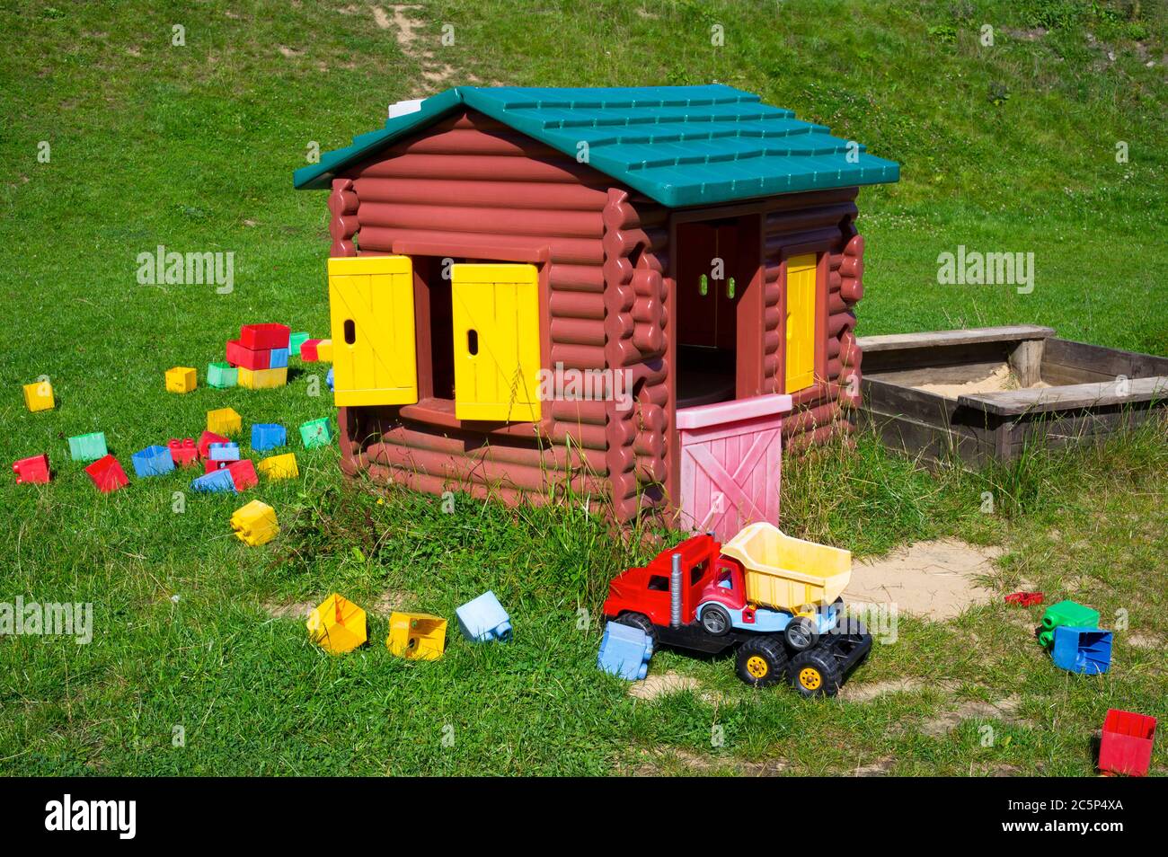 Spielplatz für Kinder - Spielzeugauto, Sandkasten, kleines Haus, Plastikwürfel Stockfoto