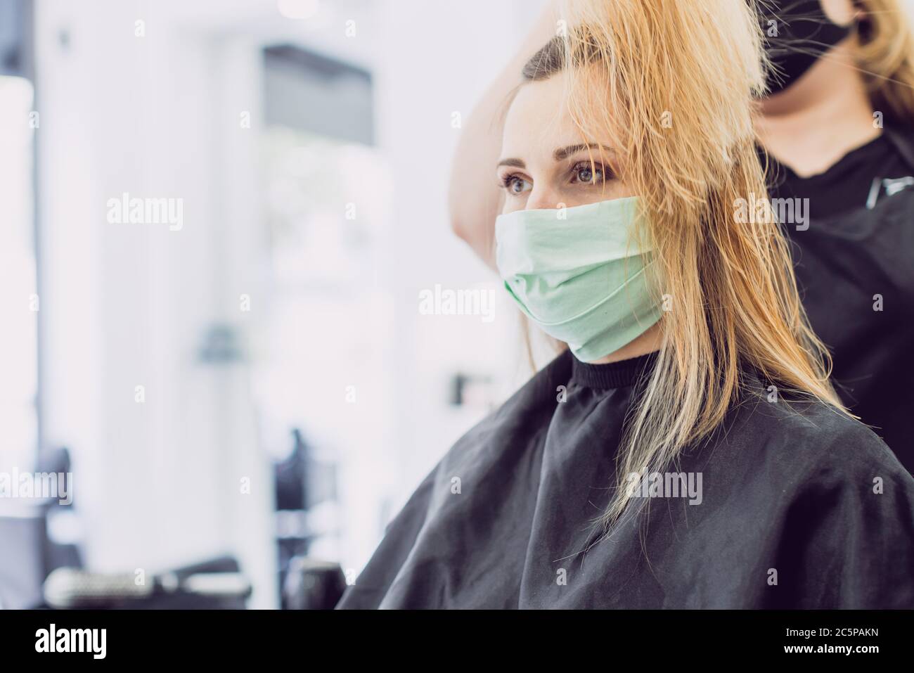 Frau, die den Friseur trägt Gesichtsmaske Stockfoto
