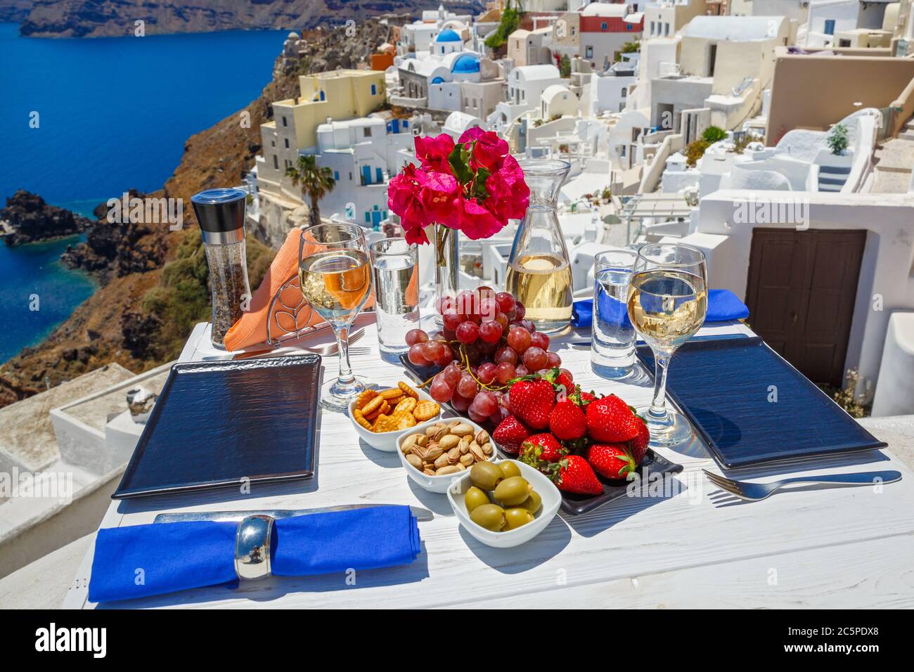 Wein, Snacks und Obst auf dem Tisch mit Blick auf das griechische Meer Stockfoto