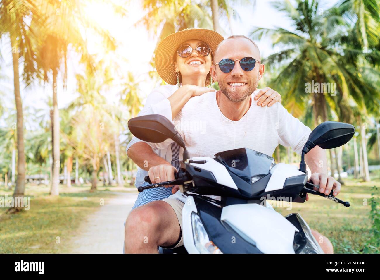 Сouple Reisende Reiten Motorrad-Roller unter Palmen. Bild des Reise-, Urlaub- und Transportkonzepts Stockfoto