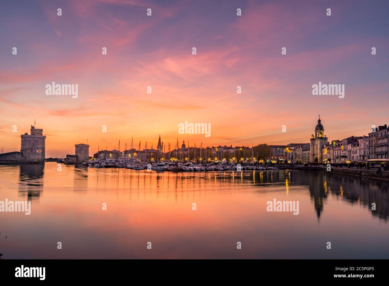 Panoramablick auf den alten Hafen von La Rochelle bei Sonnenuntergang mit seinen berühmten alten Türmen. Schöner oranger Himmel Stockfoto