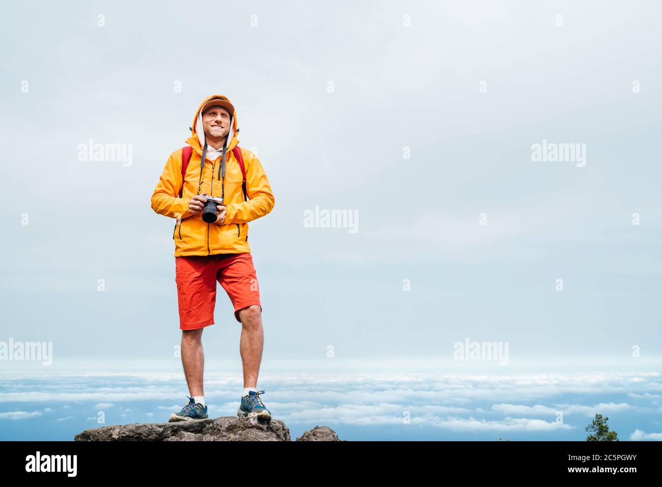 Junger Erwachsener kaukasischen Mann gekleidet sportliche Kleidung mit spiegellose Kamera auf dem Hals ein genießender Blick vom Pico Ruivo Mount 1861m - der höchste Gipfel auf der Stockfoto