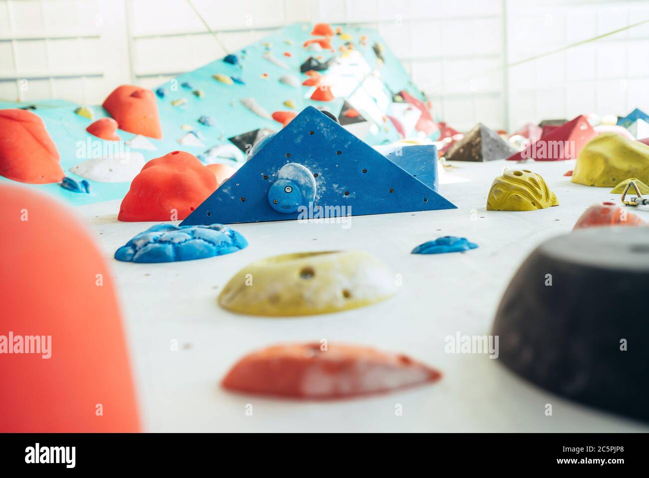 Indoor Kletterwand Halle. Mehrfarbige Klettergriffe und Volumen mit kletterndem Magnesium Chulk markiert Stockfoto