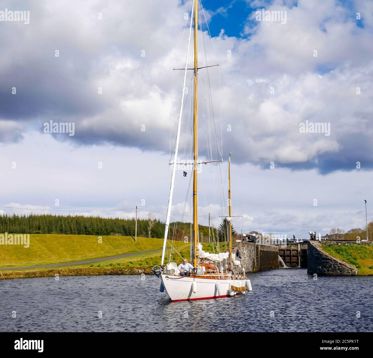 Segelyacht, die durch die Schleuse auf dem Crinan Canal, Argyll, Schottland, Großbritannien geht Stockfoto