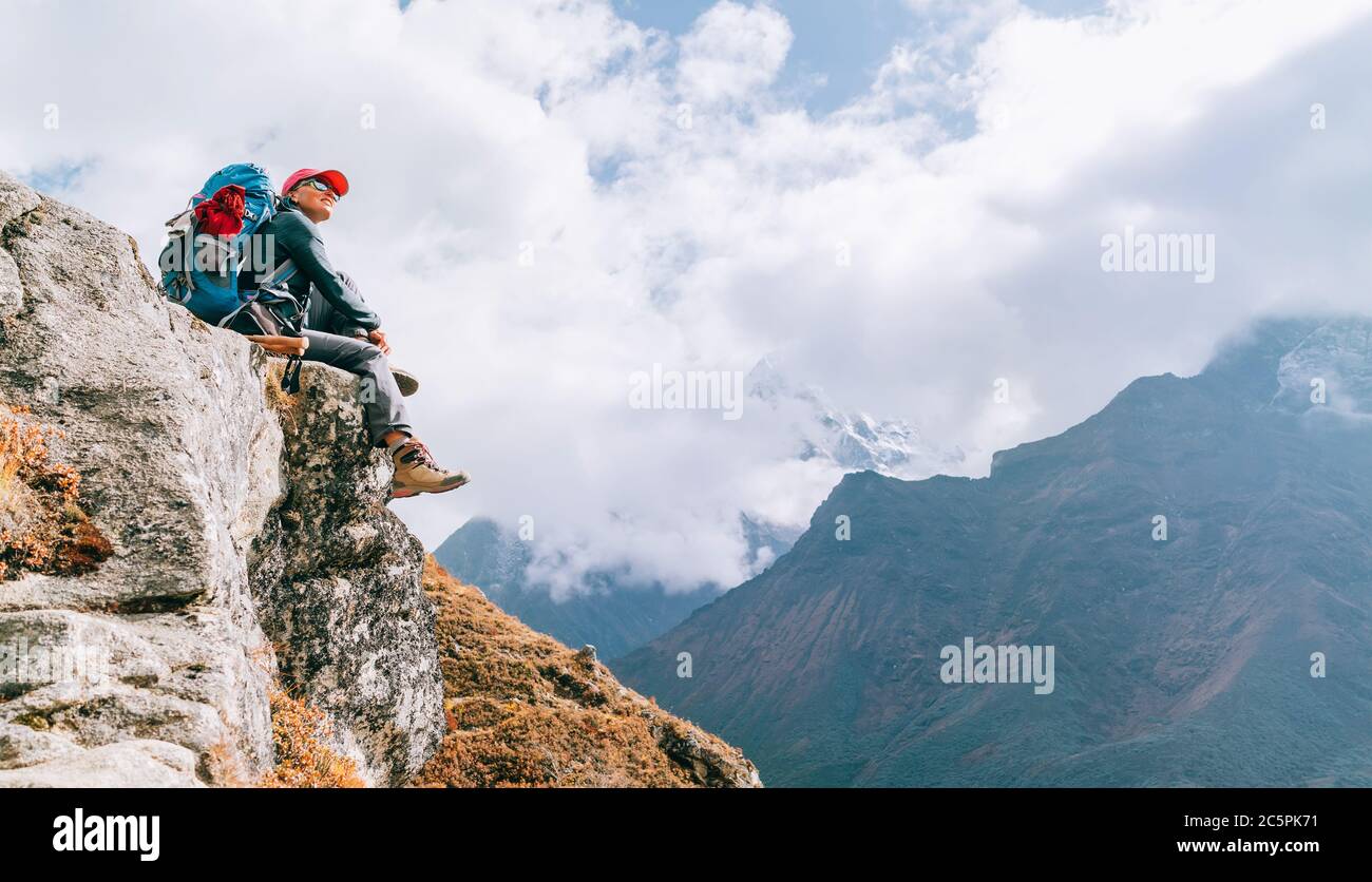 Junge Wandererin Backpacker weiblich sitzt am Klippenrand und genießt das Imja Khola Tal während der Höhenwanderung des Everest Base Camp (EBC) Route nea Stockfoto